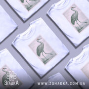 Футболка журавель стиль, біла футболка на манекені, з принтом журавля в зелених тонах, фон світло-сірий, принт оформлений у вигляді поштової марки.