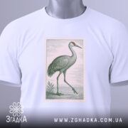 Футболка журавель стиль, біла футболка, складена на столі, з принтом журавля, фон світло-сірий, на футболці є етикетка з логотипом.