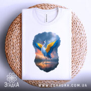 Футболка журавель України, біла, зображена зверху на плетеному кошику, фон білий, принт з журавлем з жовтими і блакитними крилами, що виглядає яскраво на фоні.