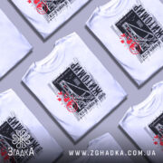 Футболка Житомир місто моє, біла футболка з коротким рукавом, зображена на манекені з металевим покриттям, фон світлий, принт містить чорні та червоні елементи з написом 'Житомир' і малюнком, що нагадує міст.