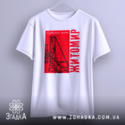 Футболка Житомир, біла, підвішена на вішалці, фон світло-сірий, принт червоний з малюнком підвісного мосту та написом 'Житомир'.