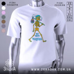 Футболка життя мандрівка, біла, зображена з правого боку, на фоні градієнтного сірого, принт з малюнком скелета, який йде з мішком, текст "ВСЕ ЖИТТЯ МАНДРІВКА" внизу.