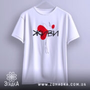 Футболка живи білого кольору, підвішена на вішалці, фон світло-сірий, принт з червоним серцем та чорним написом 'ЖИВИ', видна форма рукавів.