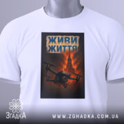 Футболка живи життя дрон, біла, складена на поверхні, фон світло-сірий, принт з дроном на фоні червоного неба та Кремлівської вежі, текст 'ЖИВИ ЖИТТЯ' у верхній частині принта, з етикеткою на комірці.