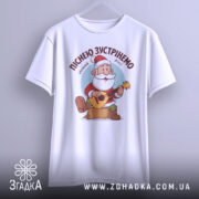 Футболка зустрінемо Новий Рік, біла, підвішена на вішалці, фон світло-сірий, принт з дідом Морозом, який грає на гітарі, текст зверху: 'Піснею зустрінемо Новий Рік!'