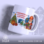 Горнятко для слухняної дівчинки, біле, зображене з правого ракурсу на світлому фоні, на ньому принт з різдвяною ялинкою, подарунками та персонажем у червоній шапці, ручка гладка, край рівний, глянець на поверхні.