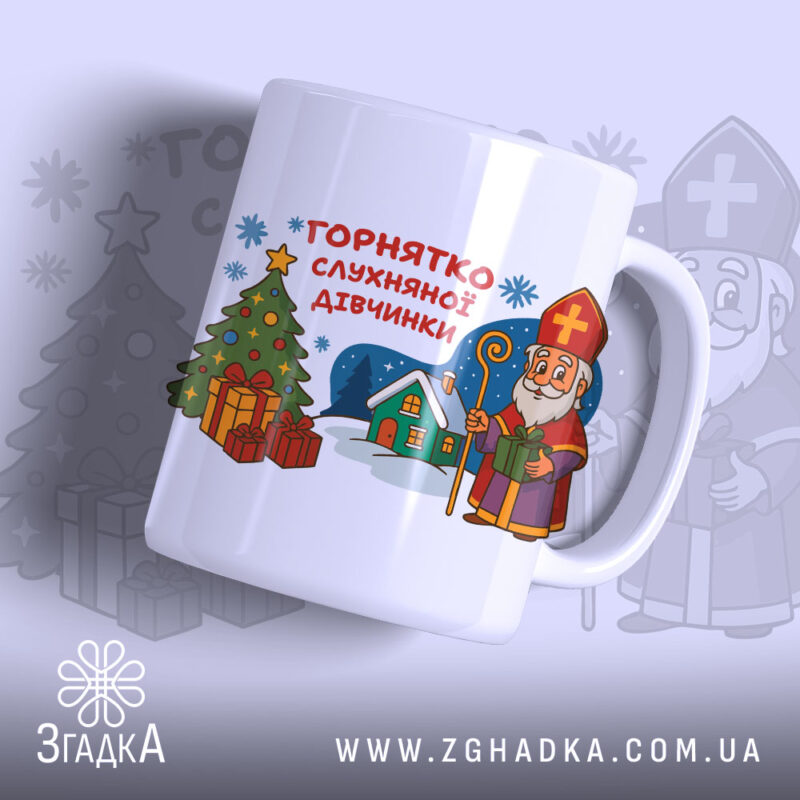 Горнятко для слухняної дівчинки, біле, зображене з правого ракурсу на світлому фоні, на ньому принт з різдвяною ялинкою, подарунками та персонажем у червоній шапці, ручка гладка, край рівний, глянець на поверхні.
