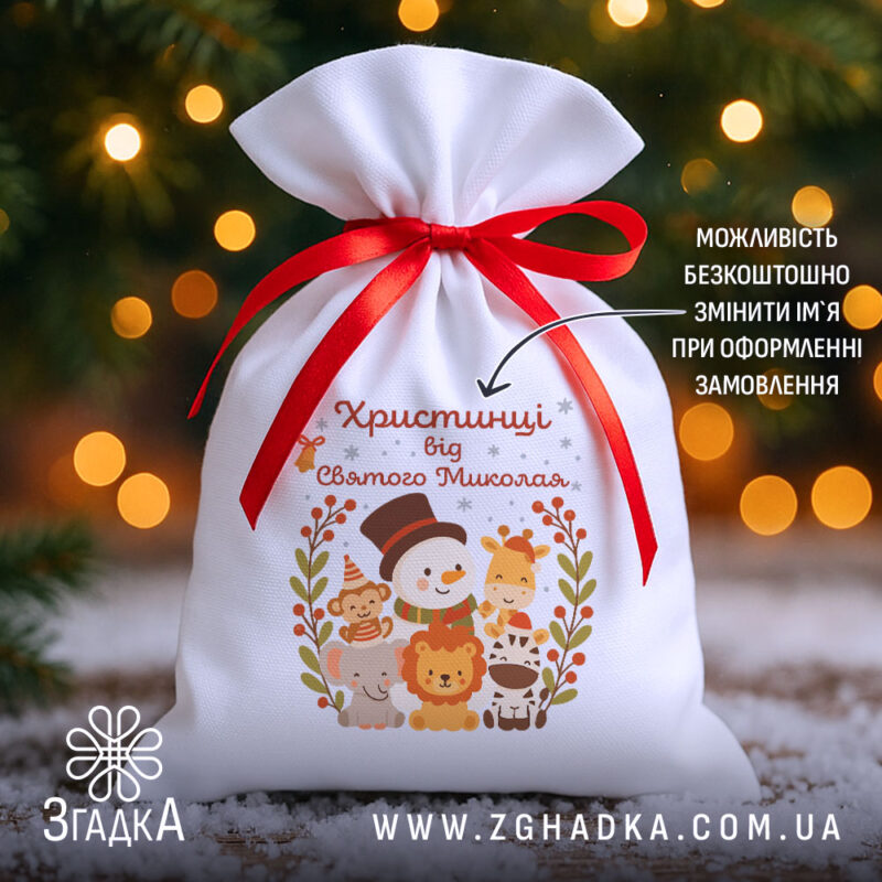 Іменна Торбинка до Миколая на фоні ялинки й вогників, білий габардин 20×30 см з червоною стрічкою та принтом зі сніговиком і звірятками.