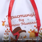 Іменна Торбинка до Миколая крупним планом, деталізація шрифту персоналізації та фактури габардину.