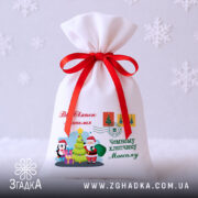 Іменний дитячий подарунковий мішечок — білий габардин із принтом і червоною стрічкою на білому фоні.