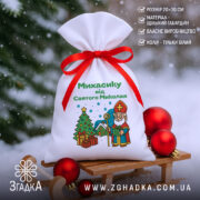Іменний Мішечок для подарунків на санчатах серед ялинкових куль із позначками розміру та матеріалу.
