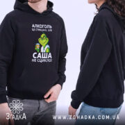 Худі алкоголь це страшно. Темно-синій колір, ракурс з боку, фон білий. Принт з персонажем у зеленому кольорі, що тримає стакан з напоєм. Є кишеня-«кенгуру», капюшон та манжети на рукавах.