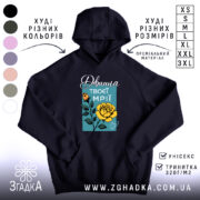 Худі дівчина твоєї мрії, темно-синього кольору, з капюшоном, ракурс спереду, на фоні видно кольорові варіанти худі. Принт з жовтою трояндою та написом на блакитному фоні, є кишеня-«кенгуру», манжети та пояс виконані в класичному стилі.