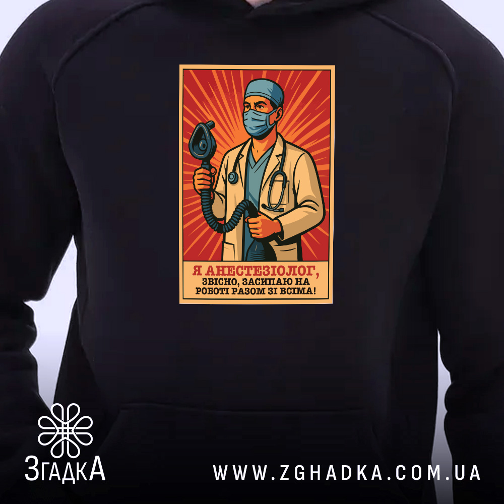 Худі для лікаря анестезіолога, темно-синього кольору, з капюшоном, з близького ракурсу видно принт з лікарем-анестезіологом, який тримає медичний інструмент, фон червоний, манжети та пояс з еластичного матеріалу.