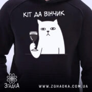Худі для любителів вина. Темно-синій колір, зображення з близького ракурсу, фон світлий. Принт з котом, який тримає келих вина, текст: 'КІТ ДА ВІНЧИК' розташований над малюнком. Капюшон видимий, манжети та пояс стандартні.