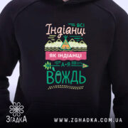 Худі я вождь чорного кольору, з капюшоном, з близького ракурсу. Принт на грудях яскравий, з текстом і малюнками, кишеня-«кенгуру» не видно, манжети не помітні.