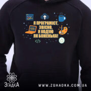 Худі подарунок для програміста, чорного кольору, з ракурсу спереду, на фоні нейтрального кольору. Принт на грудях містить текст і іконки, кишеня-«кенгуру» розташована внизу, капюшон зшитий з основної частини, манжети та пояс виконані з еластичної тканини.