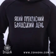 Худі прекрасний день. Темно-синій колір, ракурс спереду, фон світлий. Принт з написом "Який прекрасний блядський день" розташований на грудях. Капюшон видимий, манжети та пояс з еластичної тканини.