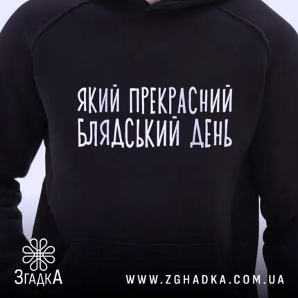 Худі прекрасний день. Темно-синій колір, ракурс спереду, фон світлий. Принт з написом "Який прекрасний блядський день" розташований на грудях. Капюшон видимий, манжети та пояс з еластичної тканини.