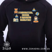 Худі вихователь стильний подарунок, чорного кольору, з капюшоном, ракурс спереду, фон білий, на грудях яскравий принт з текстом та ілюстраціями, є кишеня-«кенгуру», манжети та пояс виконані в тон.