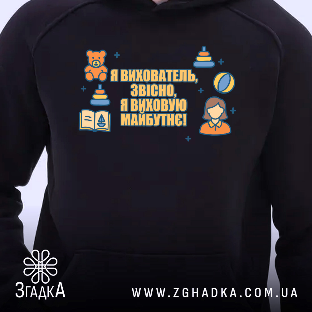 Худі вихователь стильний подарунок, чорного кольору, з капюшоном, ракурс спереду, фон білий, на грудях яскравий принт з текстом та ілюстраціями, є кишеня-«кенгуру», манжети та пояс виконані в тон.