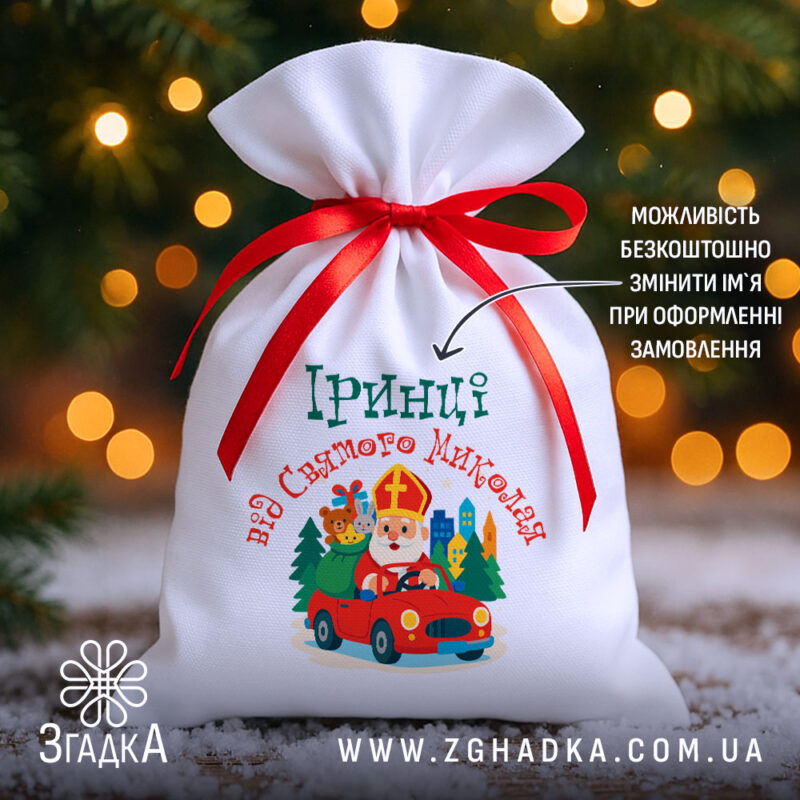 Мішечок для подарунків від Миколая на тлі ялинкових вогників, білий габардин 20×30 см, червона стрічка, іменний принт.