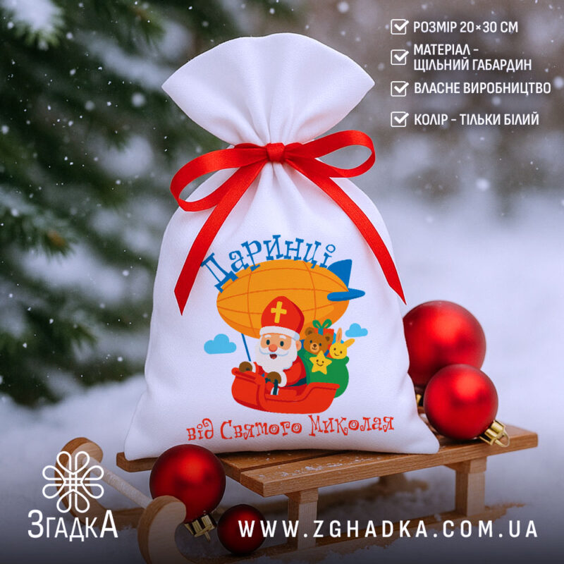 Мішечок для цукерок від Миколая на санчатах серед снігу, крупний план виробу з характеристиками, білий колір і червона стрічка.