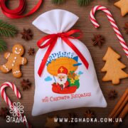 Мішечок для цукерок від Миколая у різдвяній композиції з пряниками та цукерковими тростинами, видний яскравий принт і ім’я.