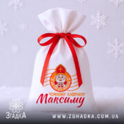 Мішечок для цукерок від Миколая на білому фоні зі сніжинками та червоною стрічкою.