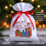 Мішечок до Дня Миколая на фоні ялинки й вогників, білий габардин 20×30 см з червоною стрічкою та принтом Святого Миколая.