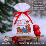 Мішечок до Дня Миколая на санчатах у снігу, білий габардин із яскравим принтом і червоною атласною зав’язкою.