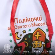 Мішечок дитячий до Миколая — крупний план друку з іменем, видно текстуру габардину й червону зав’язку.