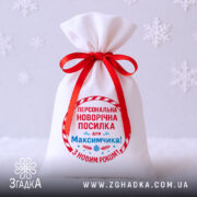 Мішечок іменний новорічний крупним планом на білому фоні зі сніжинками.