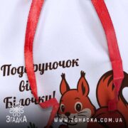 Крупний план мішечка подарунок від Білочки з деталями принта та стрічки