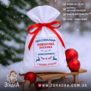 Мішечок святковий іменний на санчатах із червоною стрічкою та ялинковими прикрасами.