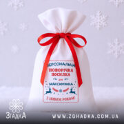 Мішечок святковий іменний крупним планом на білому фоні зі сніжинками.