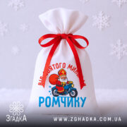 Мішечок Святого Миколая — святкове паковання з червоною стрічкою на білому фоні зі сніжинками.