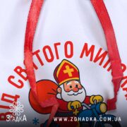 Мішечок Святого Миколая — крупний план принта з Миколаєм на мотоциклі й червоною стрічкою.