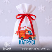Мішечок від Миколая на білому тлі зі сніжинками, загальний вигляд виробу з принтом Миколая в авто.