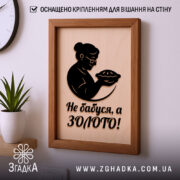 Подарункова рамка для бабусі на стіні з чорним написом і фігурою бабусі, що тримає пиріг.