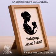 Подарункова рамка для мами з червоним написом і чорним фоном у теплій кімнаті.