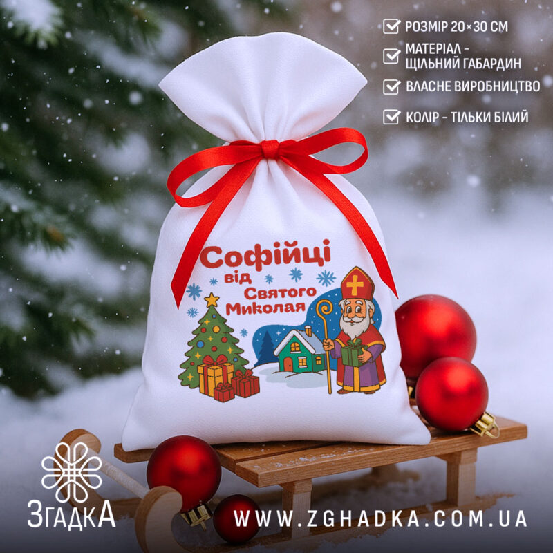 Подарунковий Іменний Мішечок до Миколая на санчатах у снігу, білий мішечок з червоною зав’язкою та святковими кулями поруч.