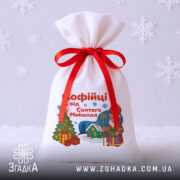 Подарунковий Іменний Мішечок до Миколая на світлому тлі зі сніжинками, контрастна червона стрічка, стильна композиція.