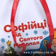 Подарунковий Іменний Мішечок до Миколая крупним планом, деталі сублімаційного друку та тексту персоналізації на білому габардині.