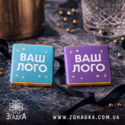 Шоколадки з логотипом у бірюзовій і фіолетовій етикетках на святковому мармуровому тлі.