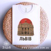 Футболка Львів білого кольору, складена на плетеній кошику, з видимим принтом театру та червоним сонцем. Текст 'ЛЬВІВ' виконаний чорним шрифтом.