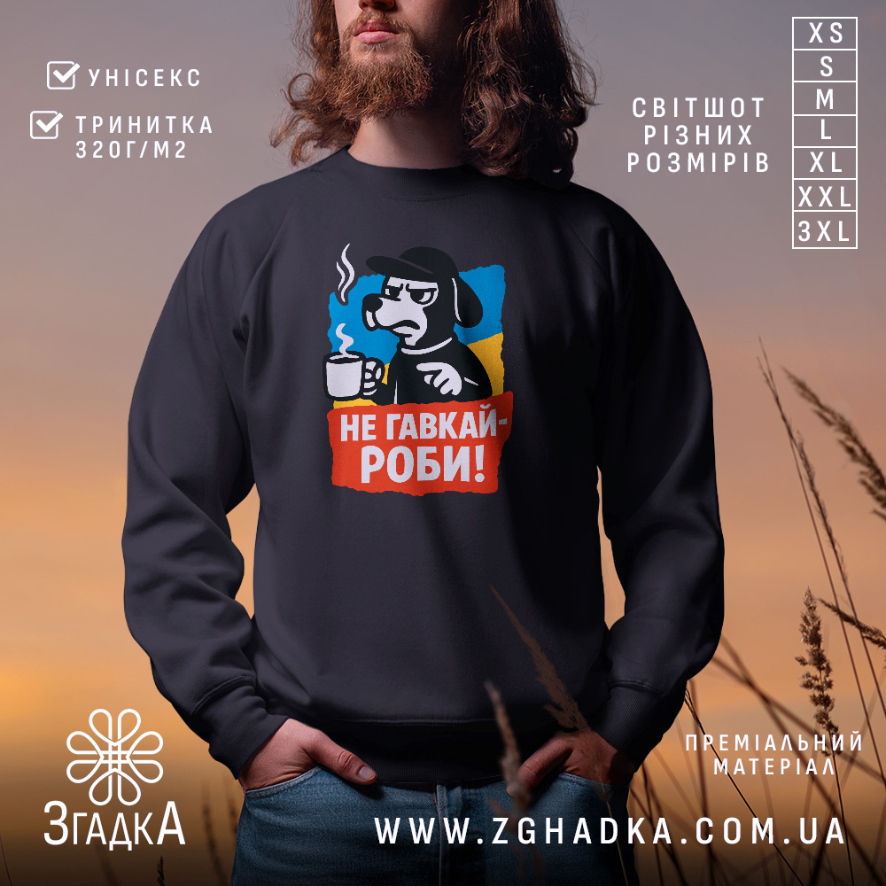 Світшот не гавкай роби, чорного кольору, з фронтальним принтом, на якому зображений персонаж з чашкою, кругла горловина, манжети та трикотажна резинка на поясі, фактура м'яка і приємна на дотик, фон розмитий, з теплими кольорами заходу сонця.