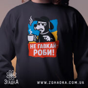 Світшот не гавкай роби, чорного кольору, з акцентом на принт, що зображає персонажа з чашкою, кругла горловина, манжети та трикотажна резинка на поясі, фактура м'яка, фон м'який і нейтральний.