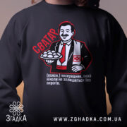 Світшот сватар для свата, чорного кольору, зображений крупним планом на чоловікові, кругла горловина, манжети, трикотажна резинка на поясі, принт з персонажем, що тримає пиріжки, яскраві деталі принта.