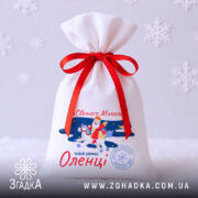 Торбинка від Святого Миколая на білому фоні зі сніжинками, червона стрічка, новорічний дизайн.